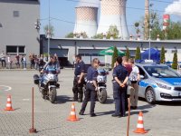 Na zdjęciu osoby zainteresowane policyjnym radiowozem i motorami.