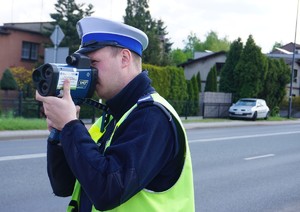 Na zdjęciu policjant podczas pomiaru prędkości.