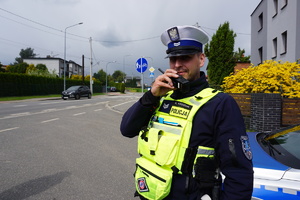 Na zdjęciu policjant podczas sprawdzania osoby przez radiostację.