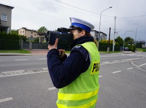 Na zdjęciu policjantka podczas pomiaru prędkości.