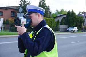Na zdjęciu policjant podczas pomiaru prędkości.