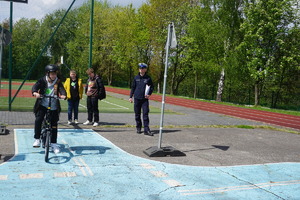 Na zdjęciu uczniowie zdają tor przeszkód na rowerze.