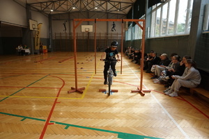 Na zdjęciu uczniowie zdają tor przeszkód na rowerze.