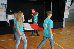 Na zdjęciu uczniowie niosą flagę Polski.